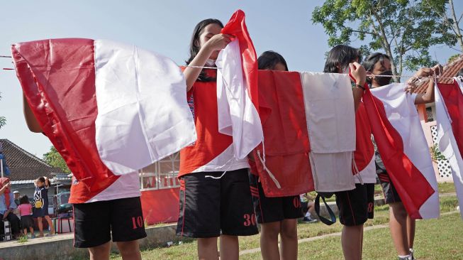 Sejumlah pelajar menjemur bendera saat pencucian bendera merah putih masal di kompleks SMK Bhumi Phala Parakan Temanggung, Jawa Tengah, Kamis (4/8/2022). ANTARA FOTO/Anis Efizudin