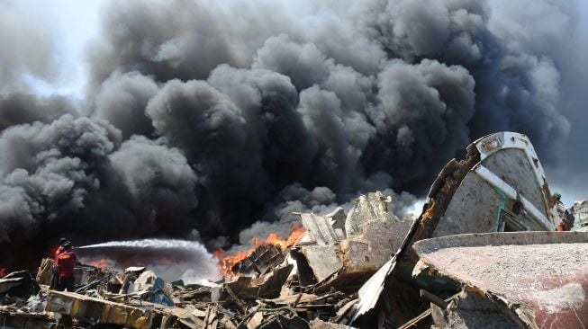 Petugas pemadam kebakaran memadamkan api saat terjadi kebakaran rongsokan perahu dan kapal di Pelabuhan Panarukan, Situbondo, Jawa Timur, Kamis (4/8/2022).  ANTARA FOTO/Seno