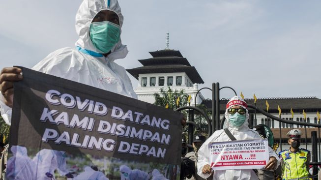 Peserta aksi yang tergabung dalam Forum Komunikasi Honorer Fasilitas Pelayanan Kesehatan (fasyankes) Jawa Barat berunjuk rasa di depan Gedung Sate, Bandung, Jawa Barat, Jumat (5/8/2022). ANTARA FOTO/Novrian Arbi