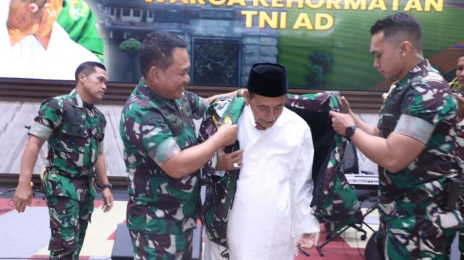 Ulama Habib Luthfi bin Yahya mengenakan jaket loreng sebagai tanda pengukuhan warga kehormatan Angkatan Darat oleh KSAD Jenderal Dudung Abdurachman di Mabes AD, Jakarta, Jumat (5/8/2022). (Dispenad)