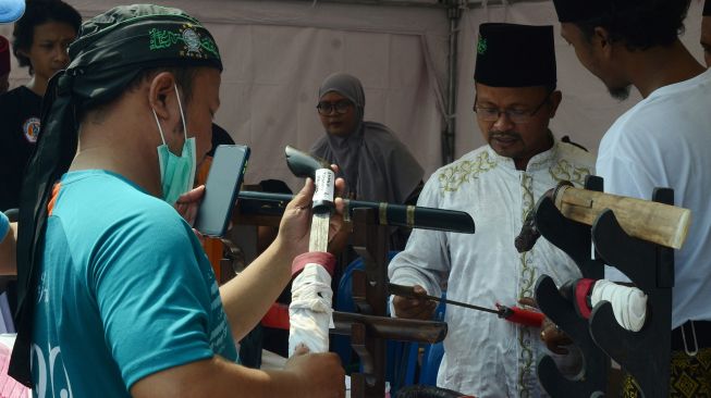 Pengunjung mengamati sejumlah golok yang dipamerkan pada "Festival Golok Cakung Harmoni Timur Jakarta 2" di Cakung, Jakarta Timur, Sabtu (6/8/2022).  ANTARA FOTO/Suwandy