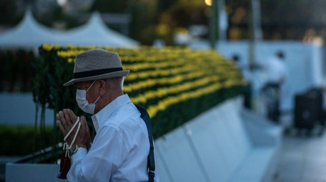 Pengunjung berdoa di depan tugu peringatan di Taman Peringatan Perdamaian Hiroshima di Hiroshima, Jepang, Sabtu (6/8/2022). [Philip FONG / AFP]