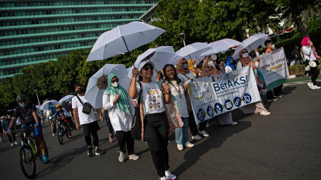 Anggota Asosiasi Ibu Menyusui Indonesia (AIMI) melakukan pawai saat berlangsung hari bebas kendaraan bermotor di kawasan Bundaran HI, Jakarta, Minggu (7/8/2022). [ANTARA FOTO/Sigid Kurniawan/nym]