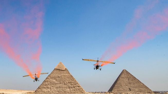 Pesawat bermanuver saat acara Pyramids Air Show 2022 di dataran tinggi Piramida Giza, Mesir, Rabu (3/8/2022). [Mahmoud Khaled / AFP]
