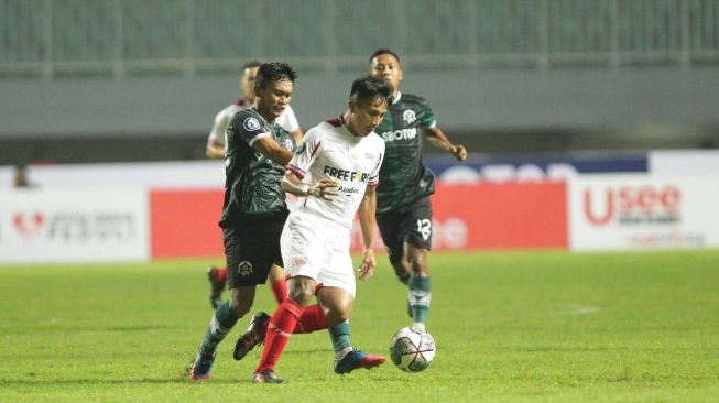 Gelandang Persis Solo, Chrystna Bagascara diadang pemain Persikabo 1973 dalam lanjutan pekan ketiga BRI Liga 1 2022/2023 di Stadion Pakansari, Cibinong, Minggu (7/8/2022). [Dok Persis Solo]