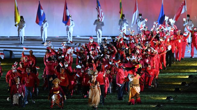 Kontingen Indonesia berjalan sambil membawa bendera dan melambaikan tangan pada penutupan ASEAN Para Games 2022 di Stadion Manahan, Solo, Jawa Tengah, Sabtu (6/8/2022). [ANTARA FOTO/Hendra Nurdiyansyah/tom]