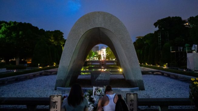 Pengunjung berdoa di depan tugu peringatan di Taman Peringatan Perdamaian Hiroshima di Hiroshima, Jepang, Sabtu (6/8/2022). [Philip FONG / AFP]