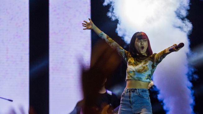 Penyanyi Isyana Sarasvati beraksi menghibur penonton saat konser musik dalam Liburland Festival di kawasan wisata Amanah Borneo Park, Banjarbaru, Kalimantan Selatan, Sabtu (6/8/2022). [ANTARA FOTO/Bayu Pratama S/rwa]