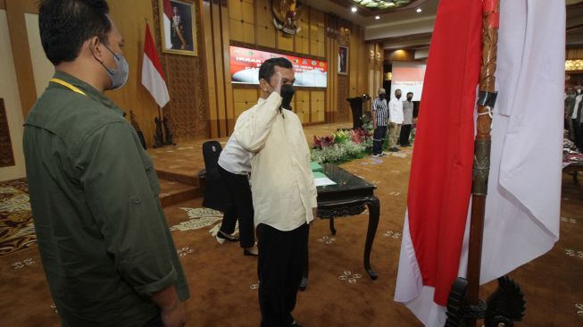 Salah satu mantan anggota Jamaah Islamiyah (JI) memberi hormat kepada bendera Merah Putih saat melakukan ikrar setia kepada NKRI dan Pancasila serta melepas baiat (janji taat) kepada JI di Kantor Gubernur Jawa Timur di Surabaya, Jawa Timur, Senin (8/8/2022). ANTARA FOTO/Moch Asim
