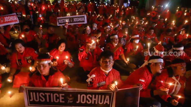 Aliansi Pemuda Batak Bersatu (PBB) memegang poster saat aksi tiga ribu lilin dan doa bersama untuk Alm Brigadir Nofriansyah Yosua Hutabarat di Taman Ismail Marzuki, Jakarta Pusat, Senin (8/8/2022). [Suara.com/Alfian Winanto]