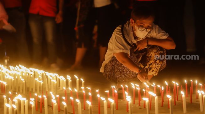 Peserta menyalakan lilin saat aksi tiga ribu lilin dan doa bersama untuk Alm Brigadir Nofriansyah Yosua Hutabarat di Taman Ismail Marzuki, Jakarta Pusat, Senin (8/8/2022). [Suara.com/Alfian Winanto]
