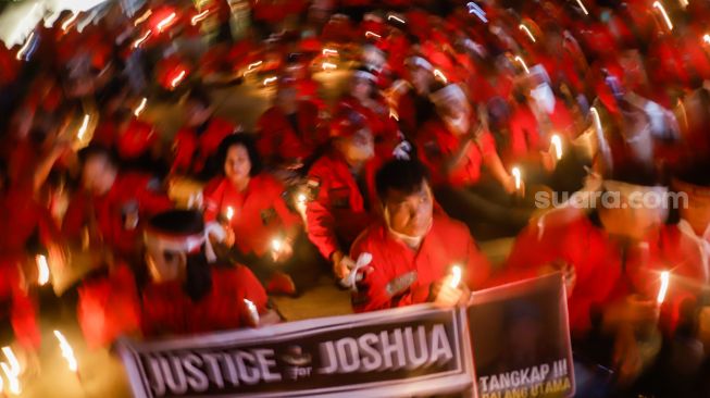 Aliansi Pemuda Batak Bersatu (PBB) memegang poster saat aksi tiga ribu lilin dan doa bersama untuk Alm Brigadir Nofriansyah Yosua Hutabarat di Taman Ismail Marzuki, Jakarta Pusat, Senin (8/8/2022). [Suara.com/Alfian Winanto]