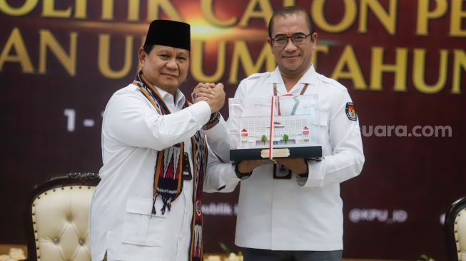 Ketua Komisi Pemilihan Umum (KPU) Hasyim Asy'ari (kanan) menberikan cinderamata kepada Ketua Umum Partai Gerakan Indonesia Raya (Gerindra) Prabowo Subianto saat Pendaftaran Partai Politik Calon Peserta Pemilu tahun 2024 di Kantor KPU, Jakarta Pusat, Senin (8/8/2022). [Suara.com/Alfian Winanto]