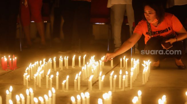 Peserta menyalakan lilin saat aksi tiga ribu lilin dan doa bersama untuk Alm Brigadir Nofriansyah Yosua Hutabarat di Taman Ismail Marzuki, Jakarta Pusat, Senin (8/8/2022). [Suara.com/Alfian Winanto]