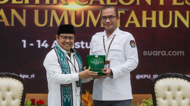 Ketua Komisi Pemilihan Umum (KPU) Hasyim Asy'ari (kanan) menerima cinderamata dari Ketua Umum Partai Kebangkitan Bangsa (PKB) Muhaimin Iskandar (kiri) saat Pendaftaran Partai Politik Calon Peserta Pemilu tahun 2024 di Kantor KPU, Jakarta Pusat, Senin (8/8/2022). [Suara.com/Alfian Winanto]