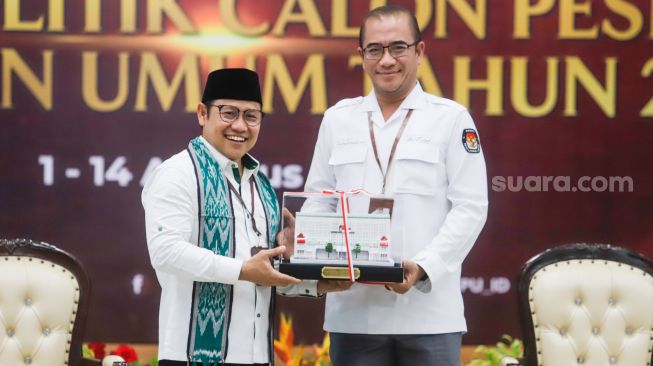 Ketua Komisi Pemilihan Umum (KPU) Hasyim Asy'ari (kanan) memberikan cinderamata kepada Ketua Umum Partai Kebangkitan Bangsa (PKB) Muhaimin Iskandar (kiri) saat Pendaftaran Partai Politik Calon Peserta Pemilu tahun 2024 di Kantor KPU, Jakarta Pusat, Senin (8/8/2022). [Suara.com/Alfian Winanto]