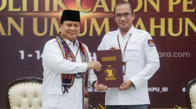 Ketua Komisi Pemilihan Umum (KPU) Hasyim Asy'ari (kanan) menerima berkas pendaftaran dari Ketua Umum Partai Gerakan Indonesia Raya (Gerindra) Prabowo Subianto saat Pendaftaran Partai Politik Calon Peserta Pemilu tahun 2024 di Kantor KPU, Jakarta Pusat, Senin (8/8/2022). [Suara.com/Alfian Winanto]
