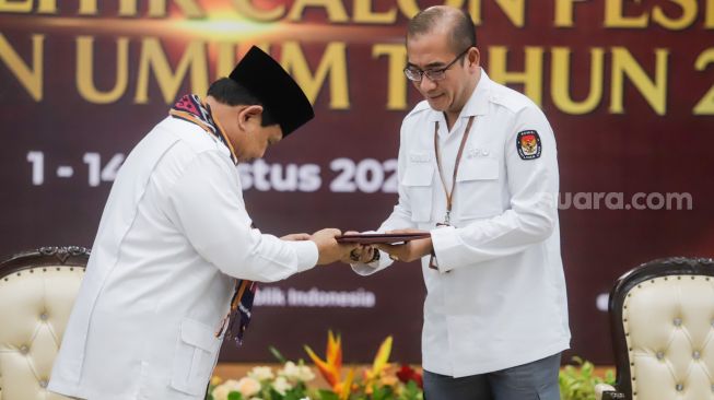 Ketua Komisi Pemilihan Umum (KPU) Hasyim Asy'ari (kanan) menerima berkas pendaftaran dari Ketua Umum Partai Gerakan Indonesia Raya (Gerindra) Prabowo Subianto saat Pendaftaran Partai Politik Calon Peserta Pemilu tahun 2024 di Kantor KPU, Jakarta Pusat, Senin (8/8/2022). [Suara.com/Alfian Winanto]