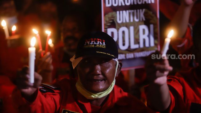 Aliansi Pemuda Batak Bersatu (PBB) memegang poster saat aksi tiga ribu lilin dan doa bersama untuk Alm Brigadir Nofriansyah Yosua Hutabarat di Taman Ismail Marzuki, Jakarta Pusat, Senin (8/8/2022). [Suara.com/Alfian Winanto]