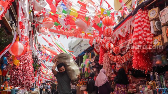 Warga memilih pernak-pernik untuk perayaan Hari Kemerdekaan ke-77 Republik Indonesia di Pasar Jatinegara, Jakarta Timur, Selasa (9/8/2022). [Suara.com/Alfian Winanto]
