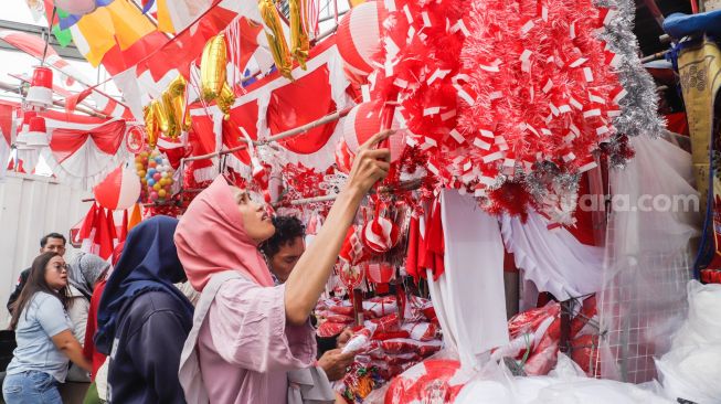 Warga memilih pernak-pernik untuk perayaan Hari Kemerdekaan ke-77 Republik Indonesia di Pasar Jatinegara, Jakarta Timur, Selasa (9/8/2022). [Suara.com/Alfian Winanto]
