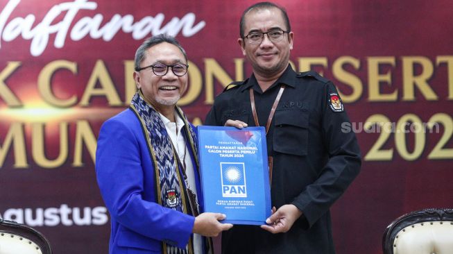 Ketua Komisi Pemilihan Umum (KPU) Hasyim Asy'ari (kanan) menerima berkas pendaftaraan dari Ketua Umum Partai Amanat Nasional (PAN) Zulkifli Hasan saat Pendaftaran Partai Politik Calon Peserta Pemilu tahun 2024 di Kantor KPU, Jakarta Pusat, Rabu (10/8/2022). [Suara.com/Alfian Winanto]