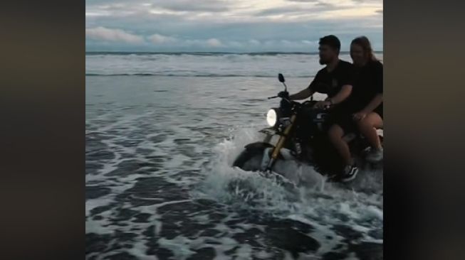 Bule naik motor nekat terabas air laut sambil memboncengkan pasangannya (TikTok)