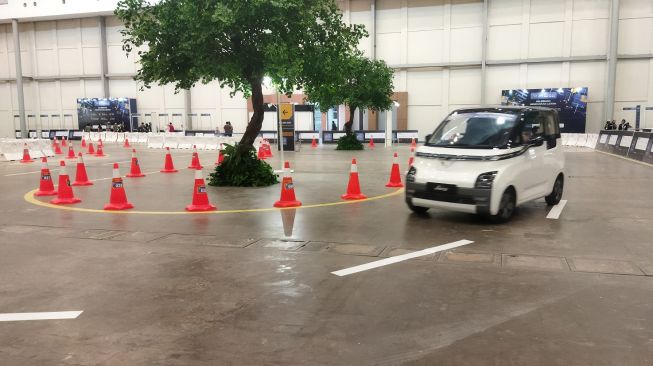 Pengunjung GIIAS 2022 sedang mengetes sebuah mobil listrik Wuling Air ev pada Kamis (11/8/2022). [Suara.com/Liberty Jemadu]