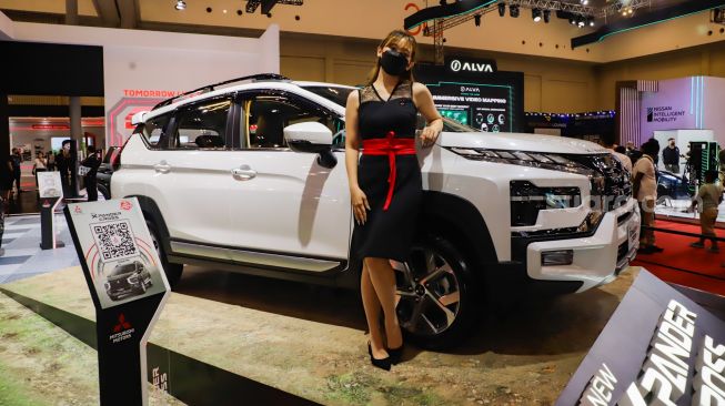 Sales Promotion Girl (SPG) berpose di depan kendaraan yang dipamerkan dalam gelaran GAIKINDO Indonesia International Auto Show (GIIAS) 2022 di Indonesia Convention Exhibition (ICE) BSD, Serpong, Tangerang, Banten, Sabtu (13/8/2022). [Suara.com/Alfian Winanto]