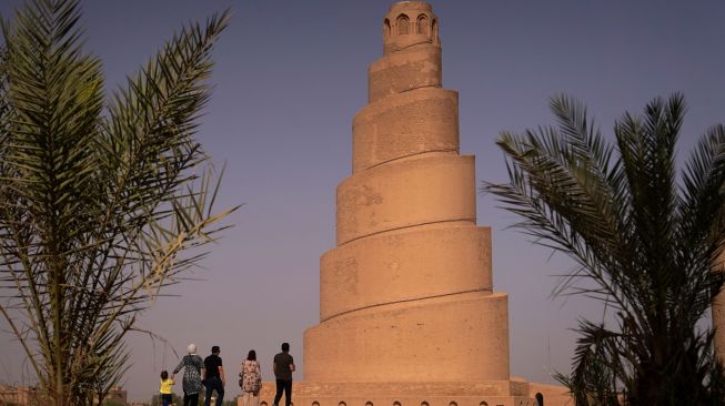 Pengunjung melihat Menara Spiral Malwiya yang berada di kompleks Masjid Agung Samarra, Baghdad, Irak, Selasa (26/7/2022). [Ismail ADNAN/AFP]