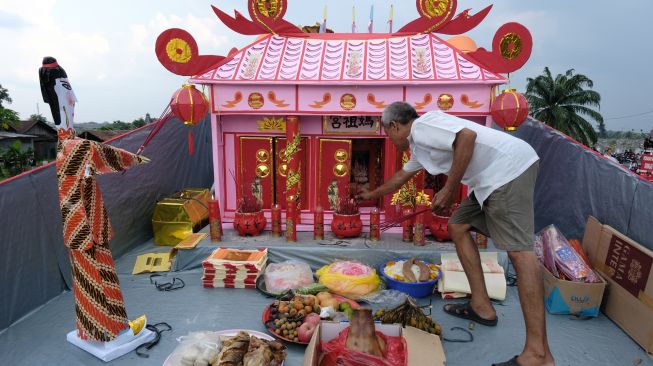 Seorang warga Tionghoa bersembayang di atas Wang Kang atau replika kapal pengantar arwah sesaat sebelum dibakar di Komplek Pemakaman Yayasan Bhakti Suci, Sungai Raya, Kabupaten Kubu Raya, Kalbar, Jumat (12/8/2022). [ANTARA FOTO/Jessica Helena Wuysang/rwa]