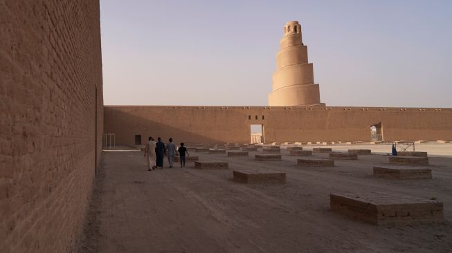 Pengunjung melihat Menara Spiral Malwiya yang berada di kompleks Masjid Agung Samarra, Baghdad, Irak, Selasa (26/7/2022). [Ismail ADNAN/AFP]