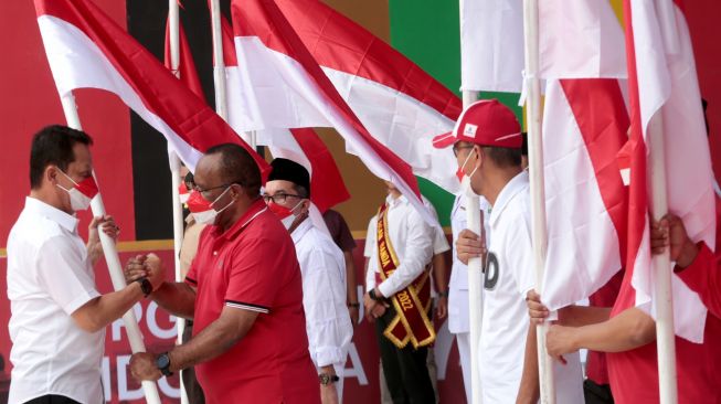 Wakil Menteri Dalam Negeri (Wamendagri) John Wempi Wetipo (kedua kiri) menyerahkan bendera kepada Penjabat Gubernur Aceh Achmad Marzuki (kiri) saat peluncuran dan penyerahan bendera pada Gerakan 10 juta Bendera Merah Putih di Banda Aceh, Aceh, Sabtu (13/8/2022). [ANTARA FOTO/Irwansyah Putra/nym]