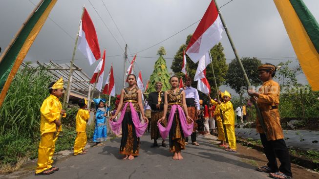 Warga membawa gunungan daun tembakau saat mengikuti Kirab Gunungan Tembakau dan Bendera Merah Putih di Gedangan, Cepogo, Boyolali, Jawa Tengah, Sabtu (13/8/2022). [ANTARA FOTO/Aloysius Jarot Nugroho/nym]