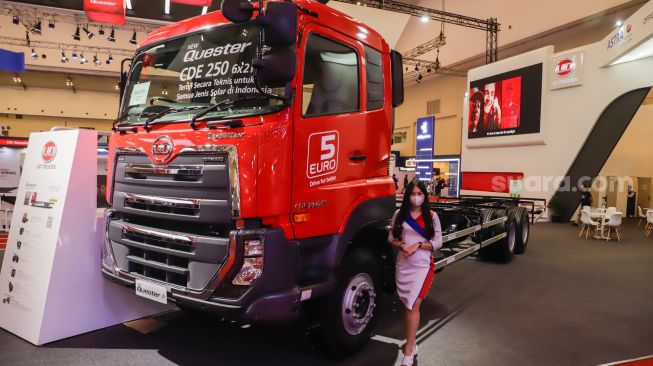 Sales Promotion Girl (SPG) berpose di depan UD Trucks New Quester CDE 250 yang dipamerkan pada ajang pameran otomotif Gaikindo Indonesia International Auto Show (GIIAS) 2022 di Indonesia Convention Exhibition (ICE) BSD, Serpong, Tangerang, Banten, Sabtu (13/8/2022). [Suara.com/Alfian Winanto]