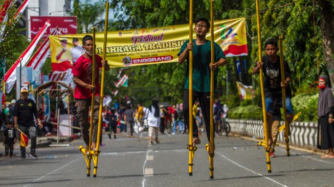 Peserta mengikuti lomba egrang pada Festival Olahraga Tradisional di Jalan Lambung Mangkurat, Banjarmasin, Kalimantan Selatan, Minggu (14/8/2022). [ANTARA FOTO/Bayu Pratama S/tom]