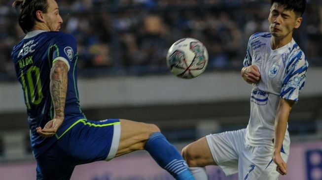 Pesepak bola Persib Bandung Marc Klok (kiri) berebut bola dengan pesepak bola PSIS Semarang Taisei Marukawa (kanan) saat pertandingan BRI Liga 1 di Stadion Gelora Bandung Lautan Api, Bandung, Jawa Barat, Sabtu (13/8/2022). [ANTARA FOTO/Raisan Al Farisi/aww]