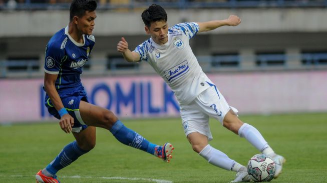 Pesepak bola Persib Bandung Rahmat Irianto (kiri) berebut bola dengan pesepak bola PSIS Semarang Taisei Marukawa (kanan) saat pertandingan BRI Liga 1 di Stadion Gelora Bandung Lautan Api, Bandung, Jawa Barat, Sabtu (13/8/2022). [ANTARA FOTO/Raisan Al Farisi/aww]