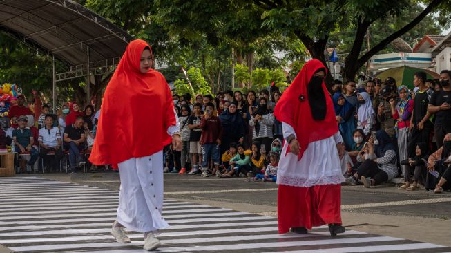 Peserta mengikuti peragaan busana jalanan (fashion street) bertema kemerdekaan di Palu, Sulawesi Tengah, Minggu (14/8/2022). [ANTARA FOTO/Basri Marzuki/tom]
