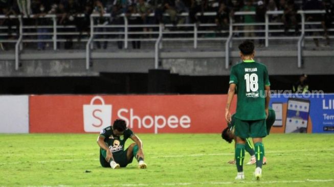 M. Hidayat, tampak terduduk lemas usai Persebaya ditahan imbang Madura United 2-2 di Stadion Gelora Bung Tomo, Surabaya, Minggu (14/8/2022). [SuaraJatim/Dimas Angga]
