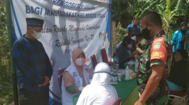 Babinsa Tanah Baru Monitoring Acara Pengobatan Gratis di Wilayah Binaan