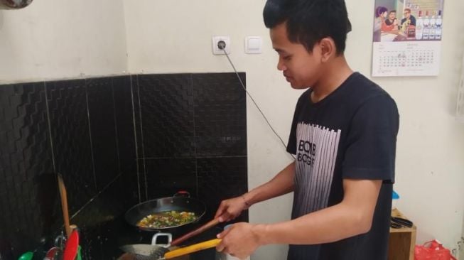 Majid, juru masak di dapur berbagi makan gratis Upajiwa Gallery, menyelesaikan masakannya, Senin (15/8/2022). (kontributor/uli febriarni) 