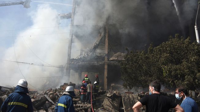 Petugas pemadam berusaha memadamkan gudang kembang api yang terbakar di Pasar Surmalu, Yerevan, Armenia, Minggu (14/8/2022). [Karen MINASYAN / AFP]