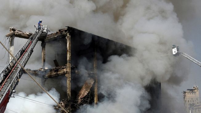 Petugas pemadam berusaha memadamkan gudang kembang api yang terbakar di Pasar Surmalu, Yerevan, Armenia, Minggu (14/8/2022). [Karen MINASYAN / AFP]