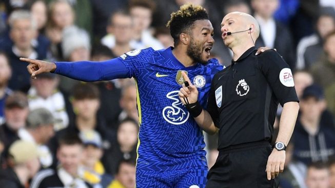 Wasit Anthony Taylor (kanan) diprotes oleh pemain Chelsea, Reece James pada laga Liga Inggris kontra Tottenham Hotspur di Stamford Bridge, London, Senin (15/8/2022) dini hari WIB. [OLI SCARFF / AFP]