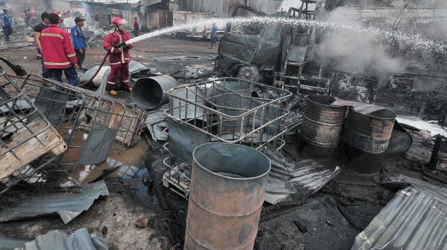 Satu unit mobil pembawa minyak hangus akibat kebakaran di salah satu gudang minyak di Jambi, Senin (15/8/2022). [ANTARA FOTO/Wahdi Septiawan/foc]
