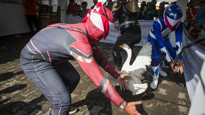 Relawan mengenakan kostum superhero mengikuti lomba memindahkan bola dari gelas yang diisi air di Sukoharjo, Jawa Tengah, Selasa (16/8/2022).  ANTARA FOTO/Mohammad Ayudha

