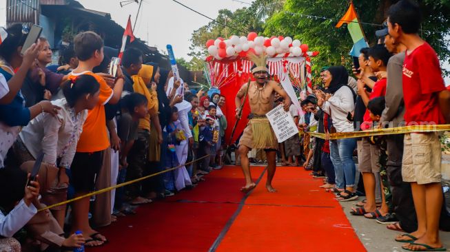 Peserta berpose saat mengikuti acara 'Ciliwung Fashion Week' di Kebon Baru, Jakarta Selatan, Rabu (17/8/2022). [Suara.com/Alfian Winanto]