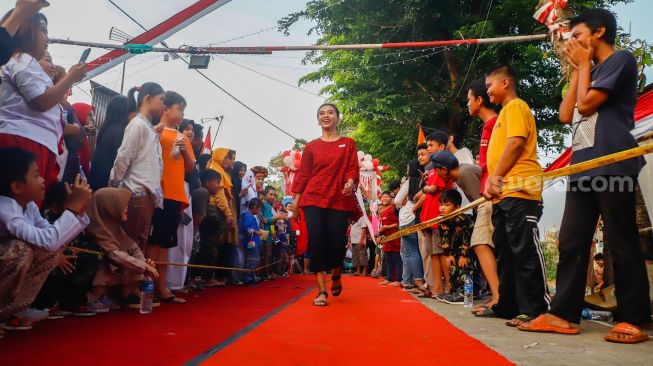 Peserta berpose saat mengikuti acara 'Ciliwung Fashion Week' di Kebon Baru, Jakarta Selatan, Rabu (17/8/2022). [Suara.com/Alfian Winanto]
