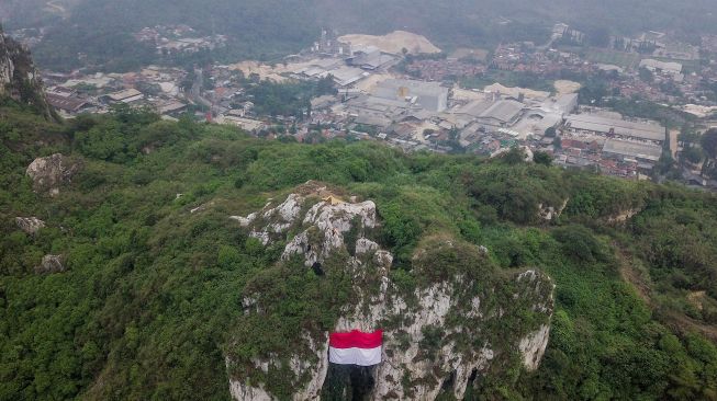 Foto udara pengibaran bendera Merah Putih raksasa saat upacara kemerdekaan di Geotheater Tebing Hawu, Padalarang, Kabupaten Bandung Barat, Jawa Barat, Rabu (17/8/2022). ANTARA FOTO/Raisan Al Farisi
